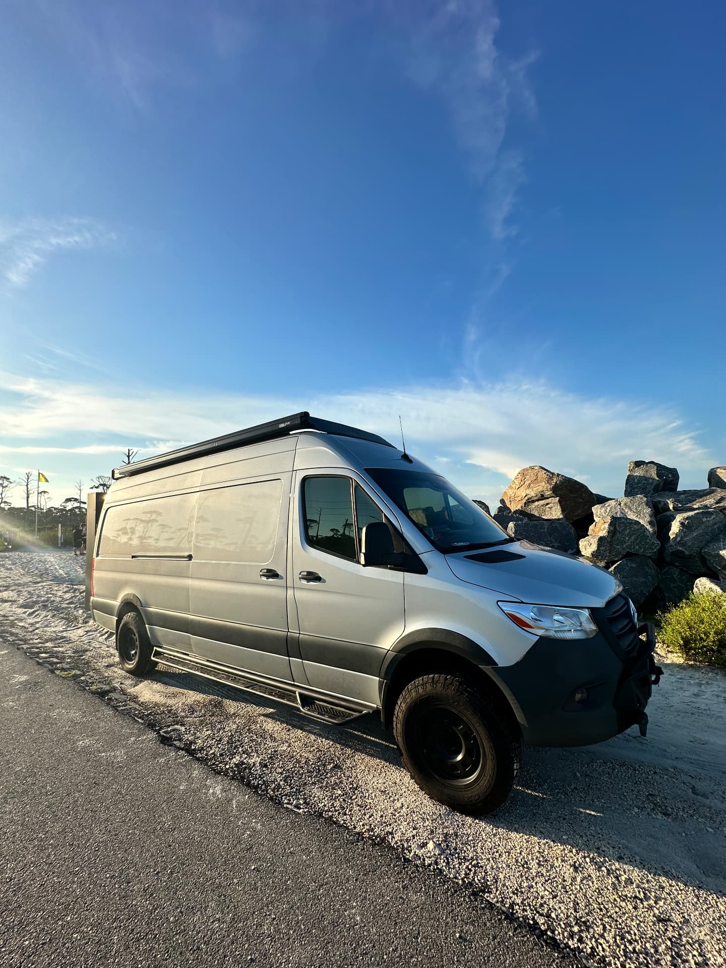 Whisper Sprinter production van on a coastal road at golden hour