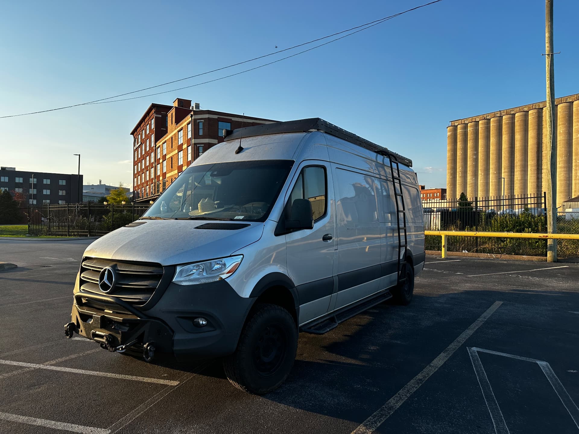 Whisper Sprinter production van parked in a city lot at sunrise