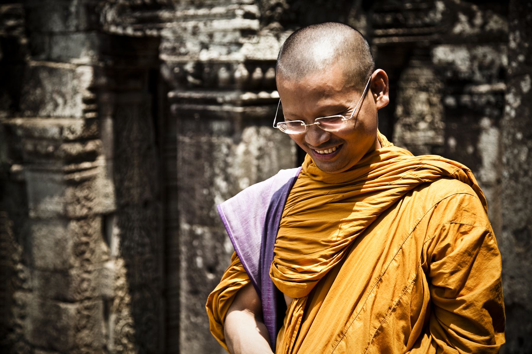 A monk in saffron robes at an ancient temple gate