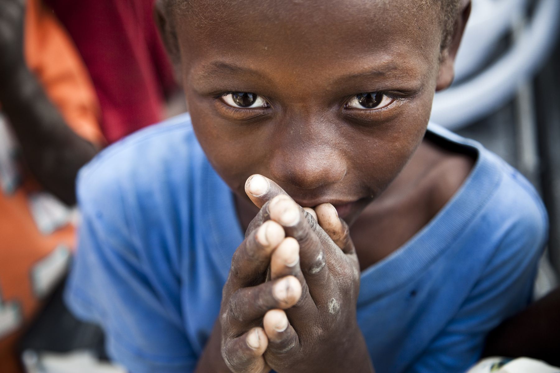 A girl resting her folded hands against her face